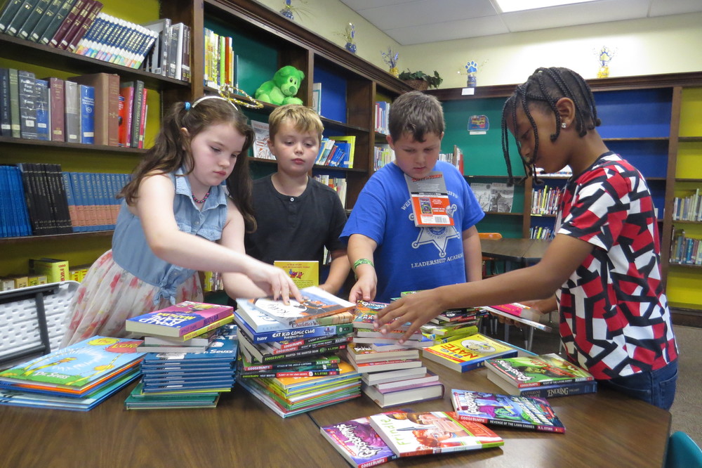  Pictured from left are Madison Elementary School students Charlie Getter, Noah Milliken, Chance Hartman and Tyquan Pugh-Davis as they peruse books provided to the school through an initiative of Books-A-Million at The Highlands.  ​