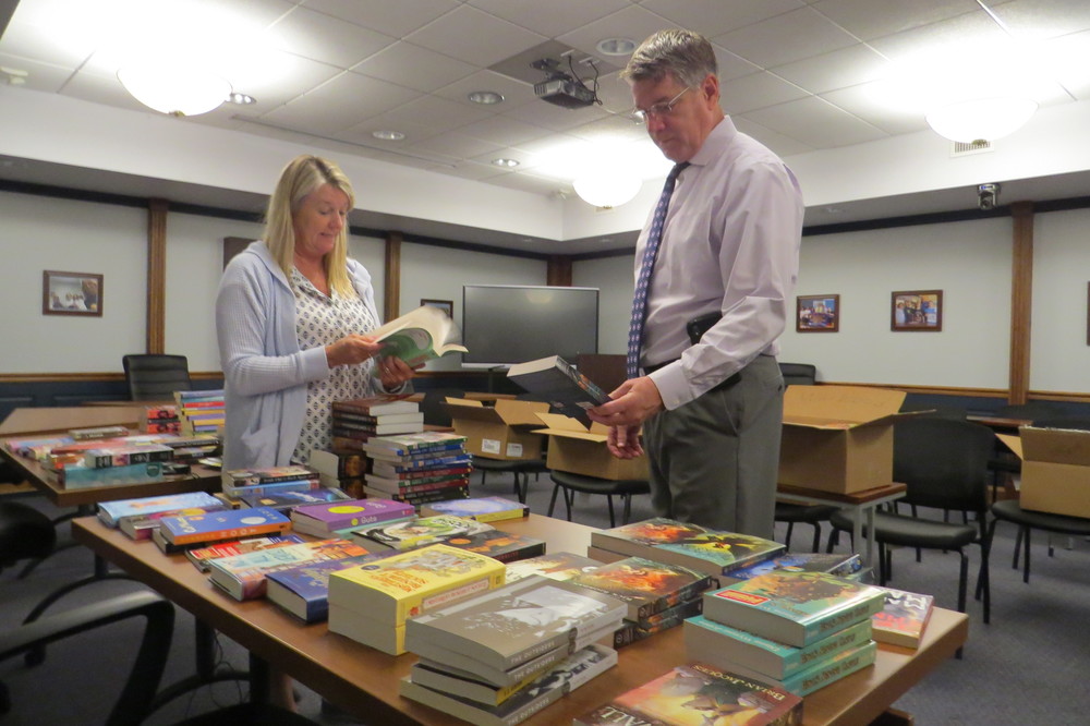 Ohio County Schools Federal Programs and Assessment Director Walt Saunders and secretary Jody Miller are shown organizing books donated to the school system through a project by Books-A-Million at The Highlands. 