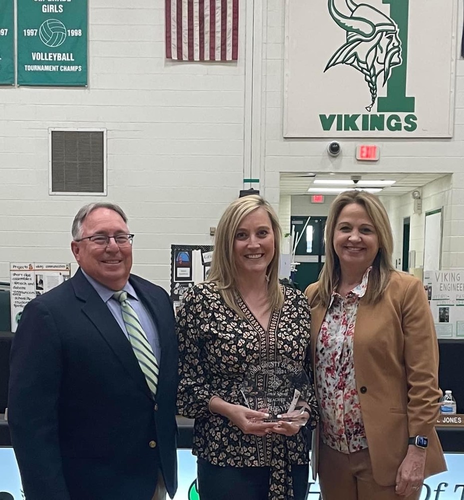 Ohio County Schools Teacher of the Year Jamie Young is shown with Board of Education President Andy Garber and Superintendent Kimberly Miller